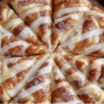 This Cinnamon-Sugar Pizza is a quick and easy dessert, made with flaky crescent roll dough, a buttery cinnamon-sugar topping, and a sweet vanilla icing drizzle. It's perfect for satisfying your sweet tooth!